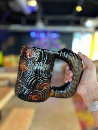 Close-up of vibrant handmade ceramic mugs with unique textures and glazes.