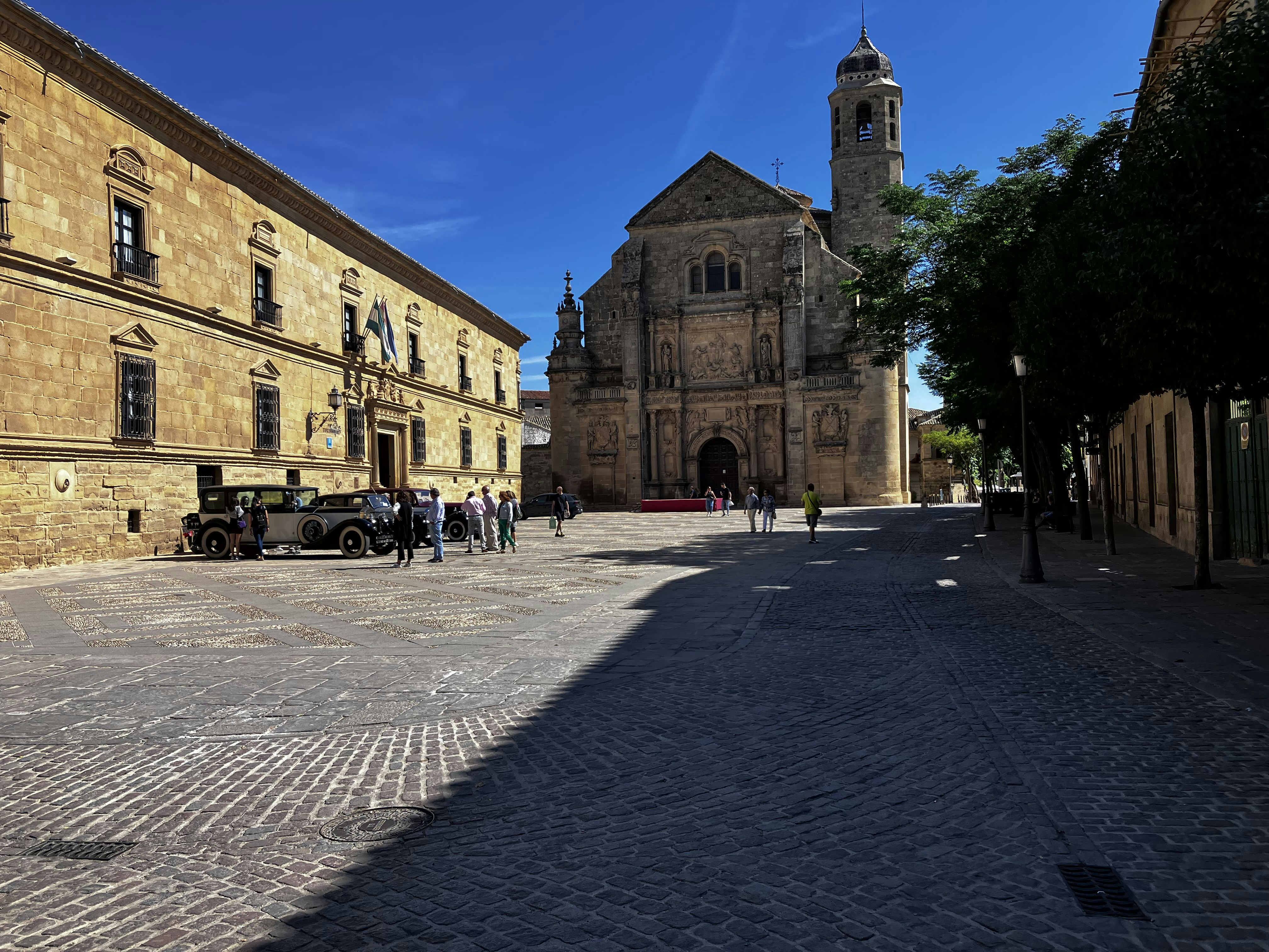 a brick road with a car and people on it