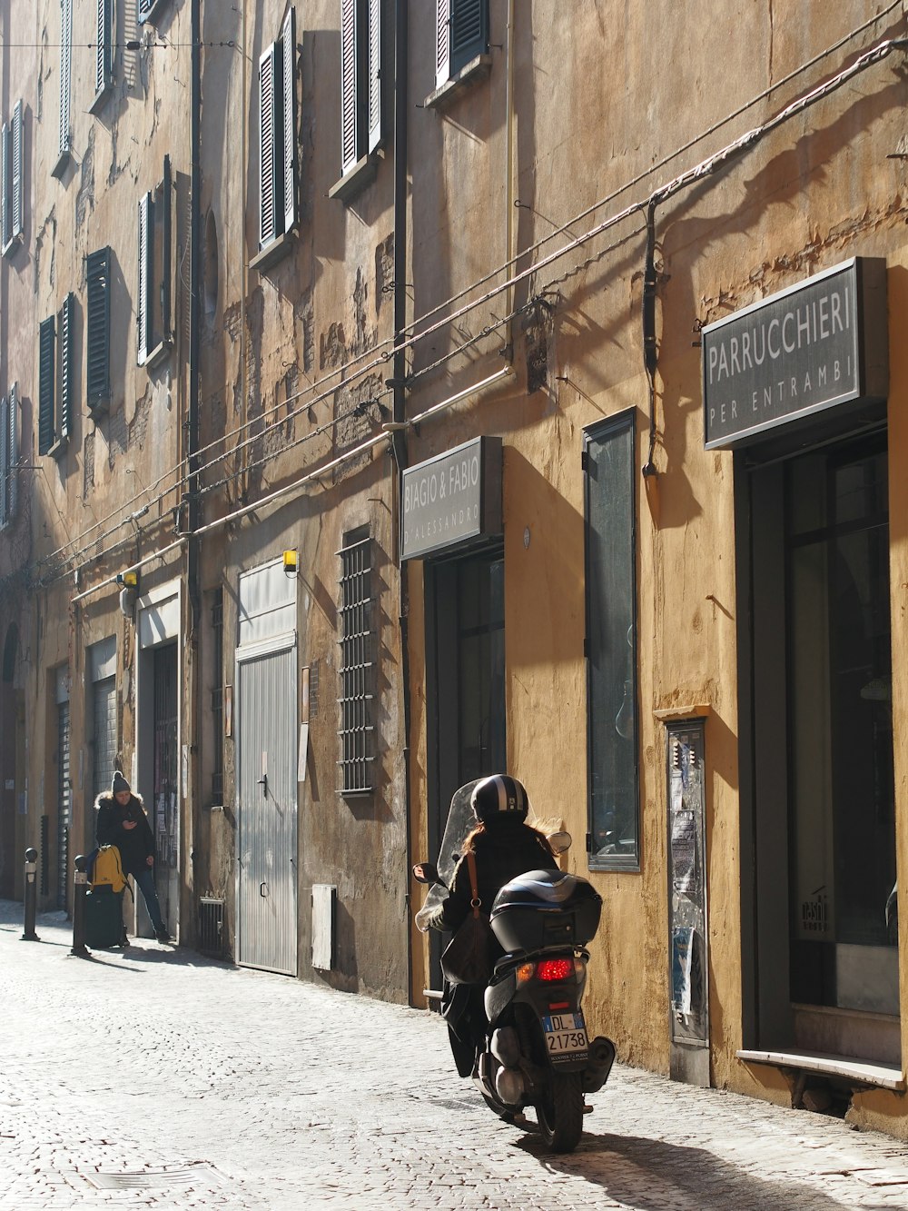 a person on a motorcycle in an alleyway