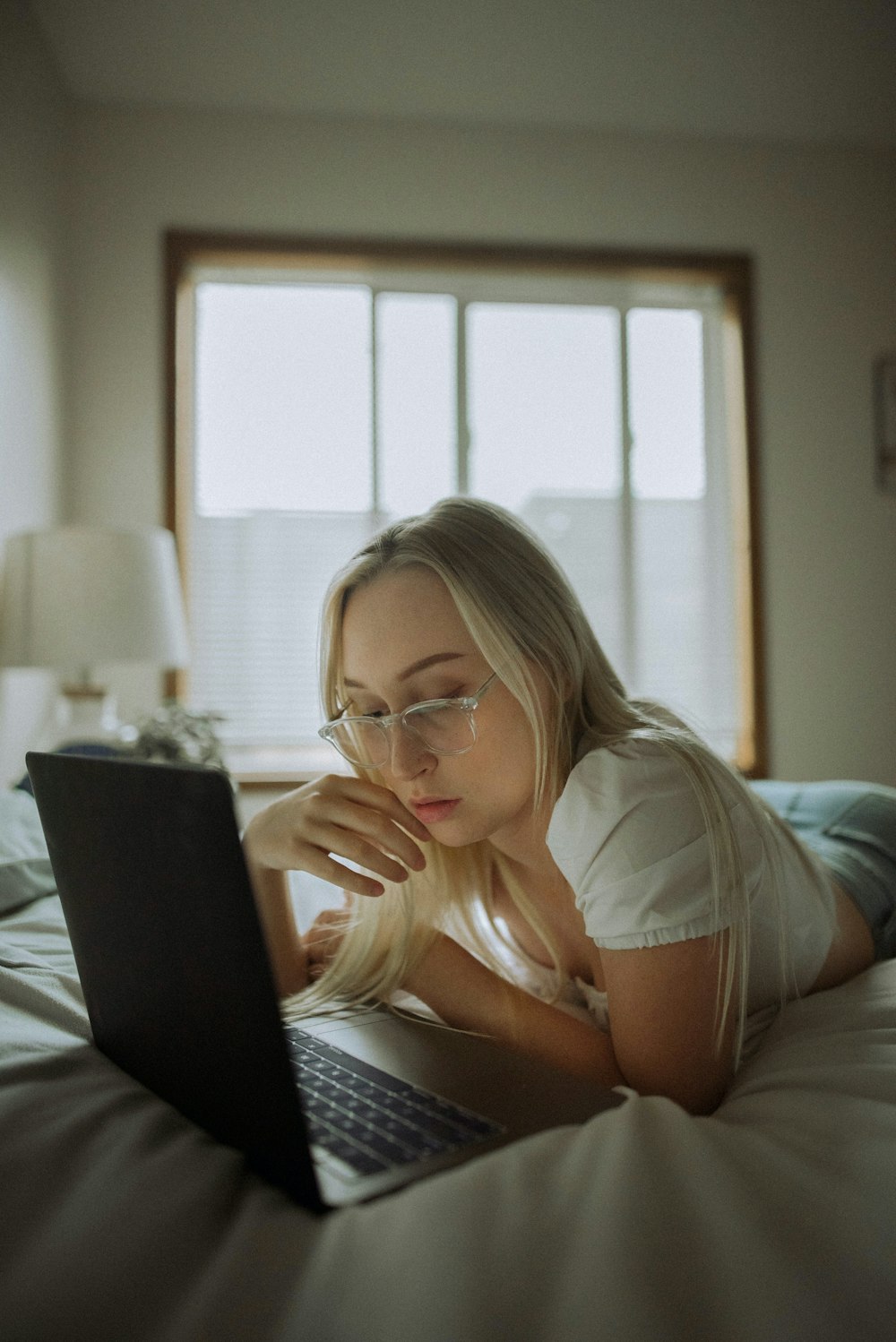 a woman sitting on a bed with a laptop