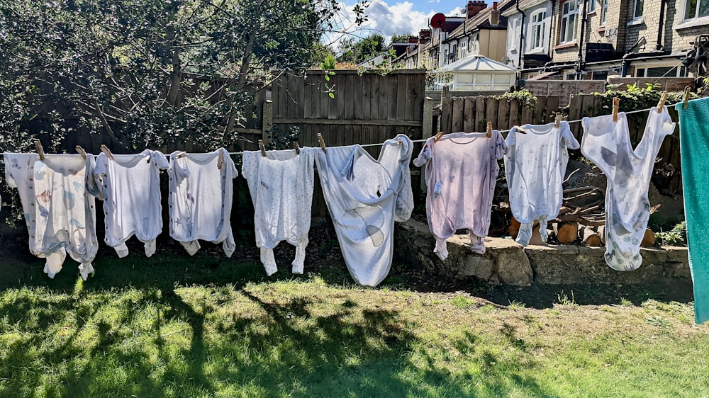 a row of white clothes on a line on a fence
