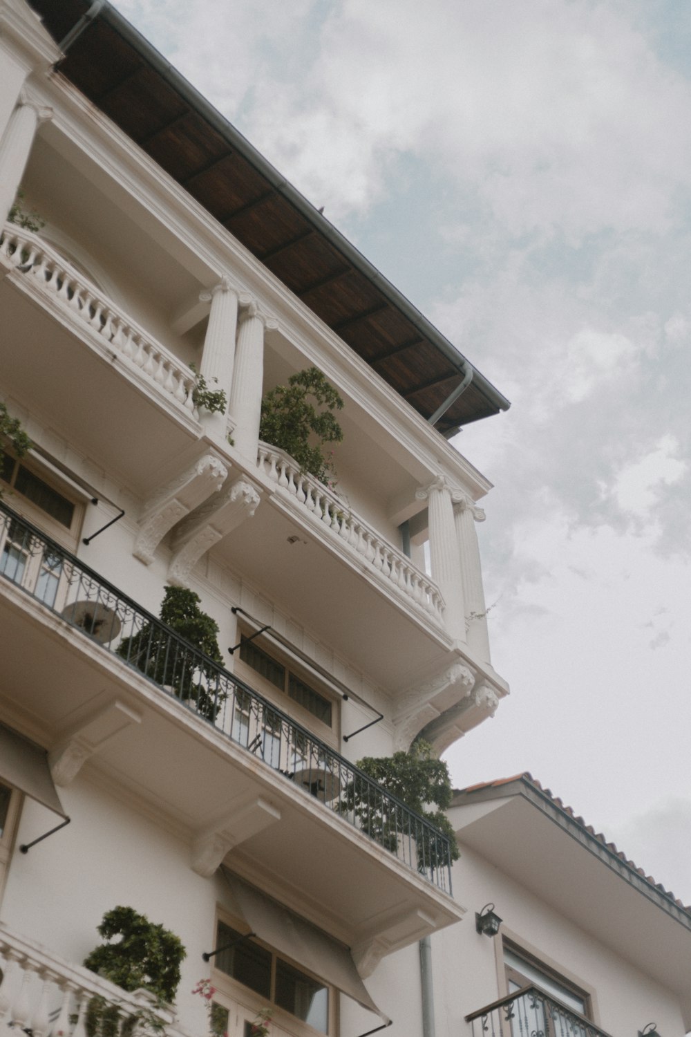 a building with balconies and plants on the roof