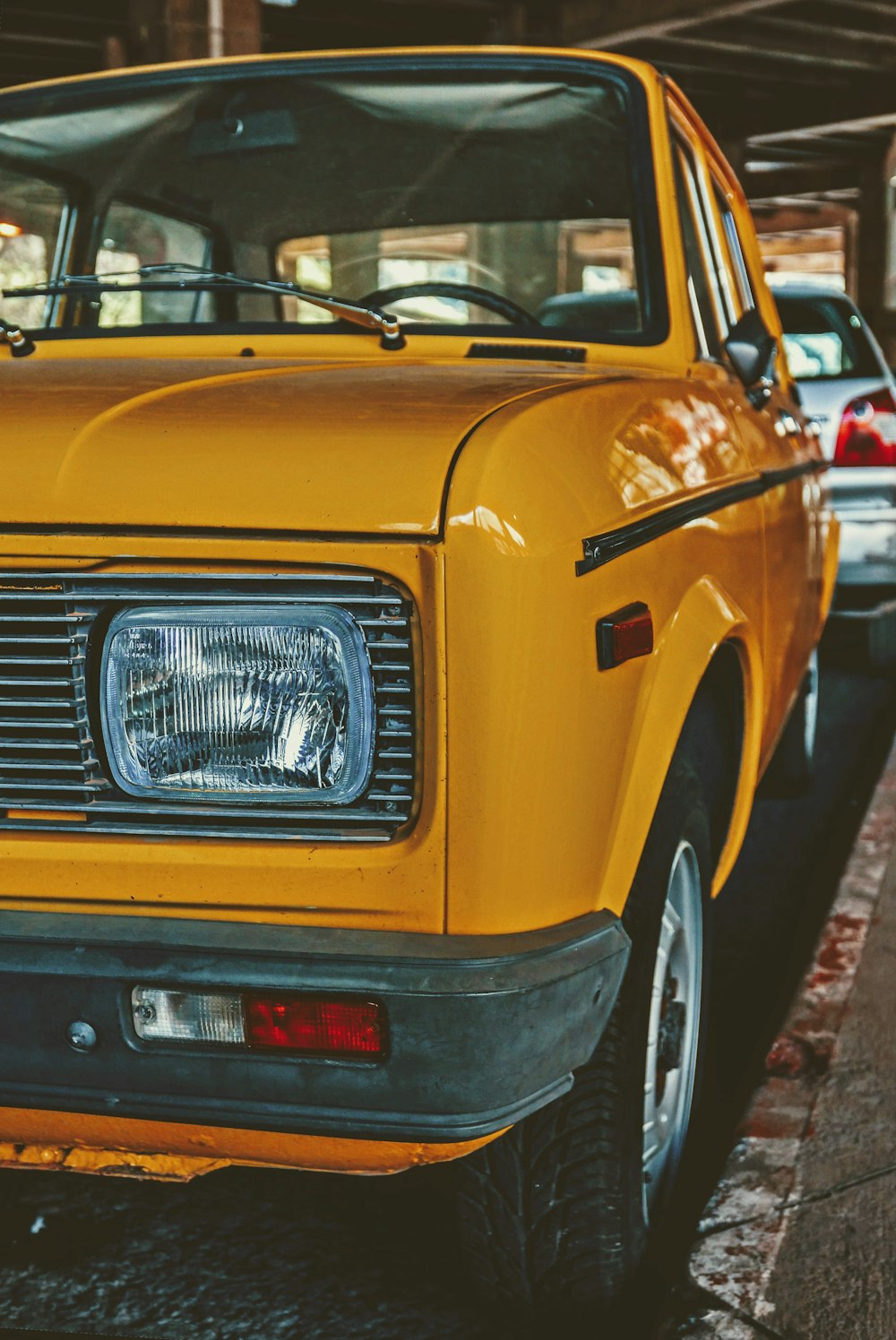 a yellow car parked on the side of a road