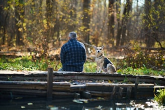 a person and a dog sitting on a dock
