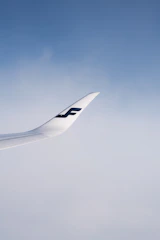 A close-up of a vintage airplane wing against a clear blue sky