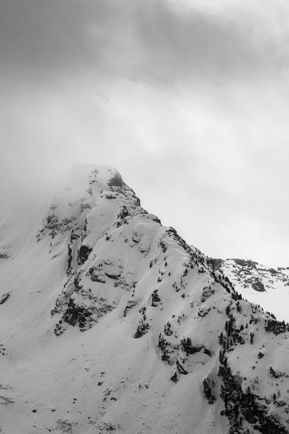 a snowy mountain with clouds