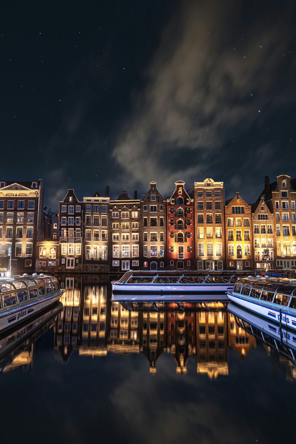 a city with a body of water and a bridge with a rainbow in the sky