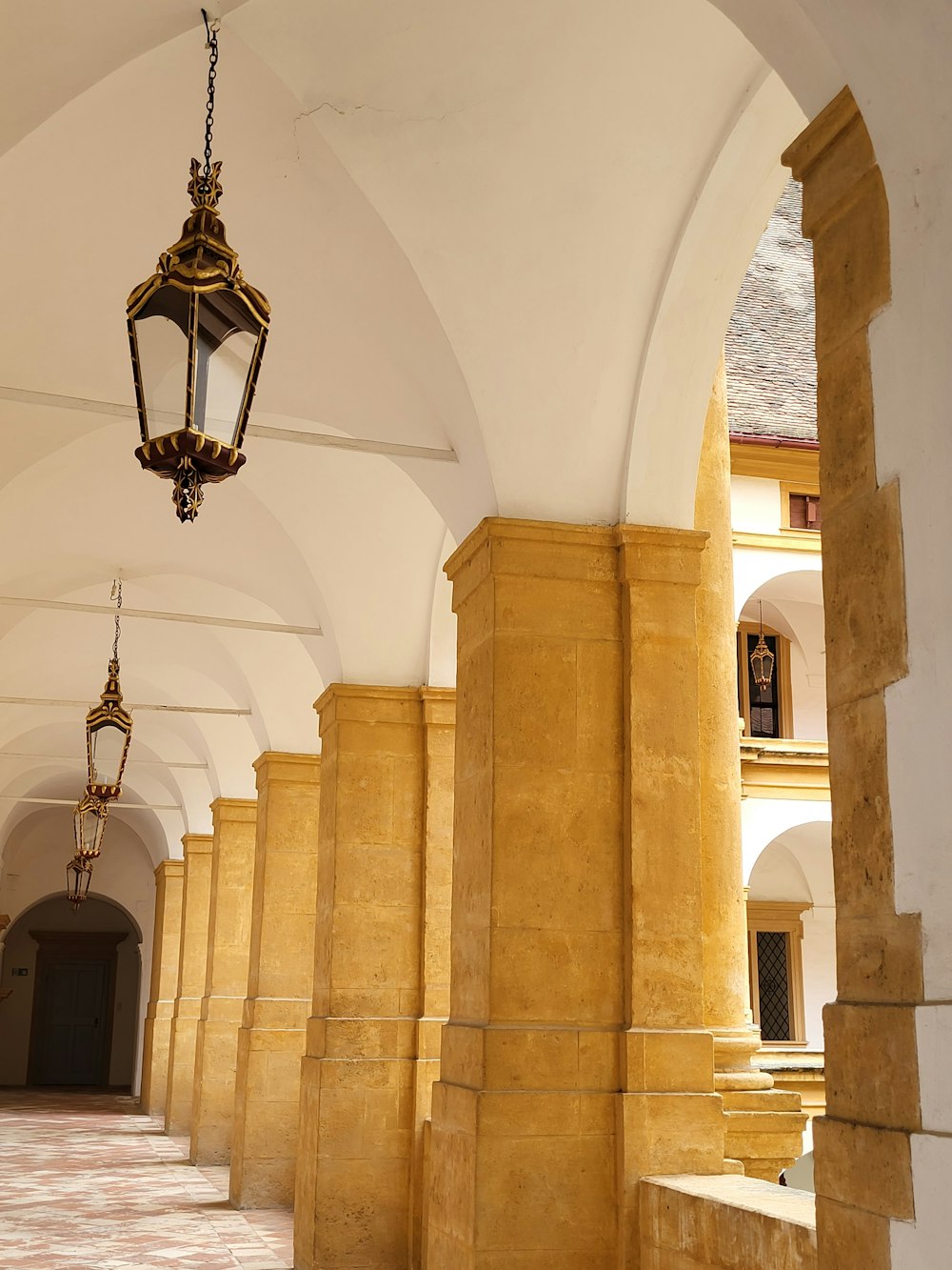 a room with a chandelier and stone pillars