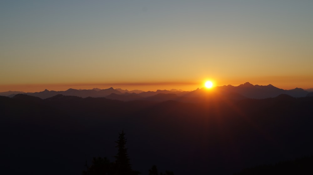 a sunset over a mountain range