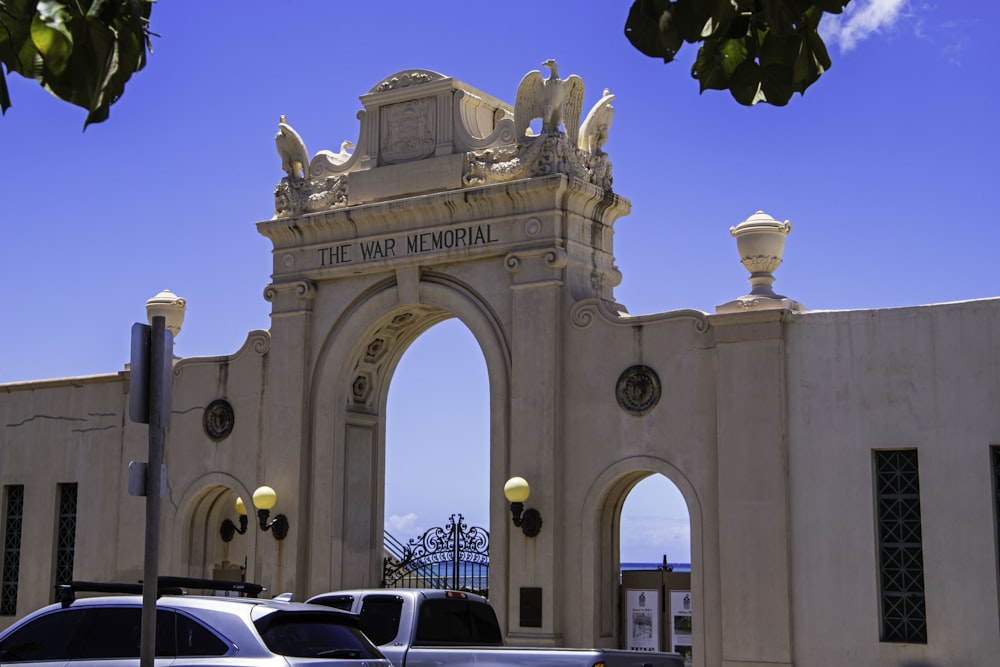 a large white building with a large arch and statues on top