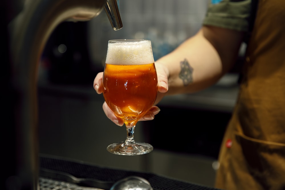 a person holding a glass of beer