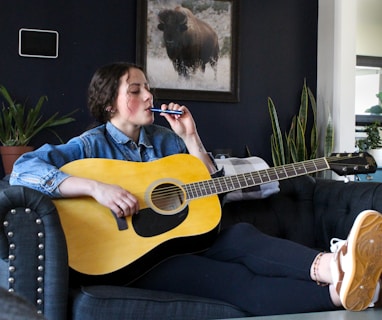 a person sitting on a couch playing a guitar