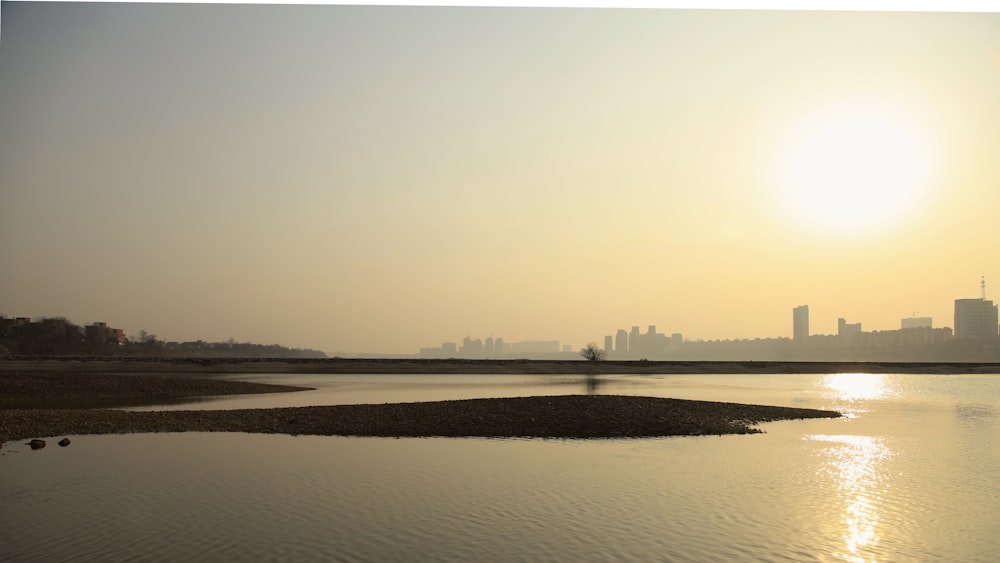 a body of water with a land with buildings in the background