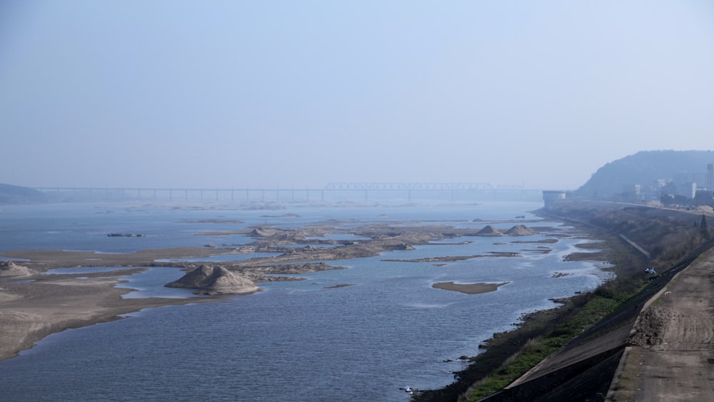 a body of water with a bridge and a city in the distance