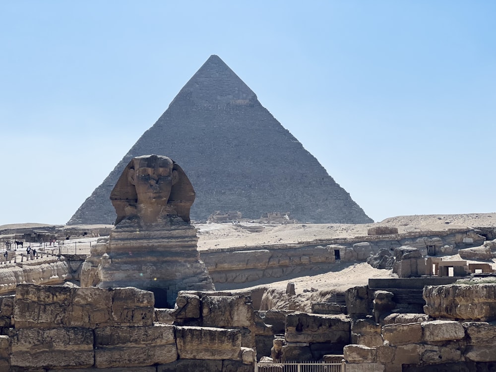 una piramide con una statua di fronte ad essa
