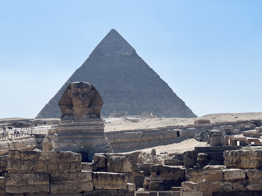 a pyramid with a statue in front of it