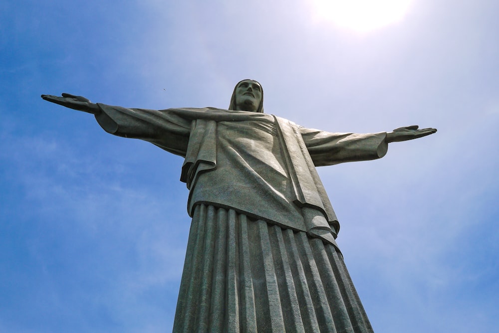 a statue of a person with Christ the Redeemer in the background