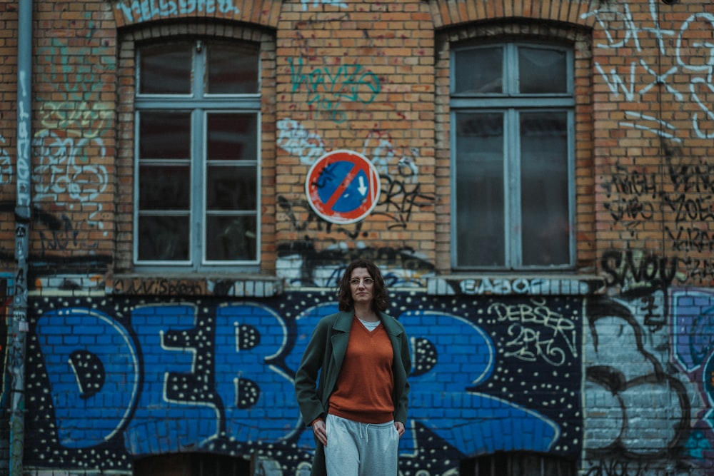 a person standing in front of a building with graffiti on it