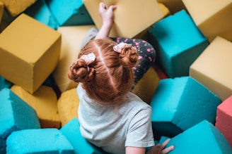 a girl lying on a colorful cube