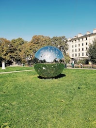a large reflective sphere in a park