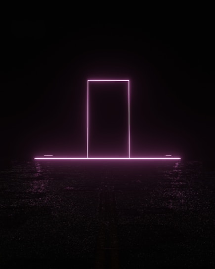 A neon pink rectangle resembling a doorway stands illuminated against a dark background. The glow from the neon light reflects subtly on the ground, creating an ethereal and futuristic atmosphere.