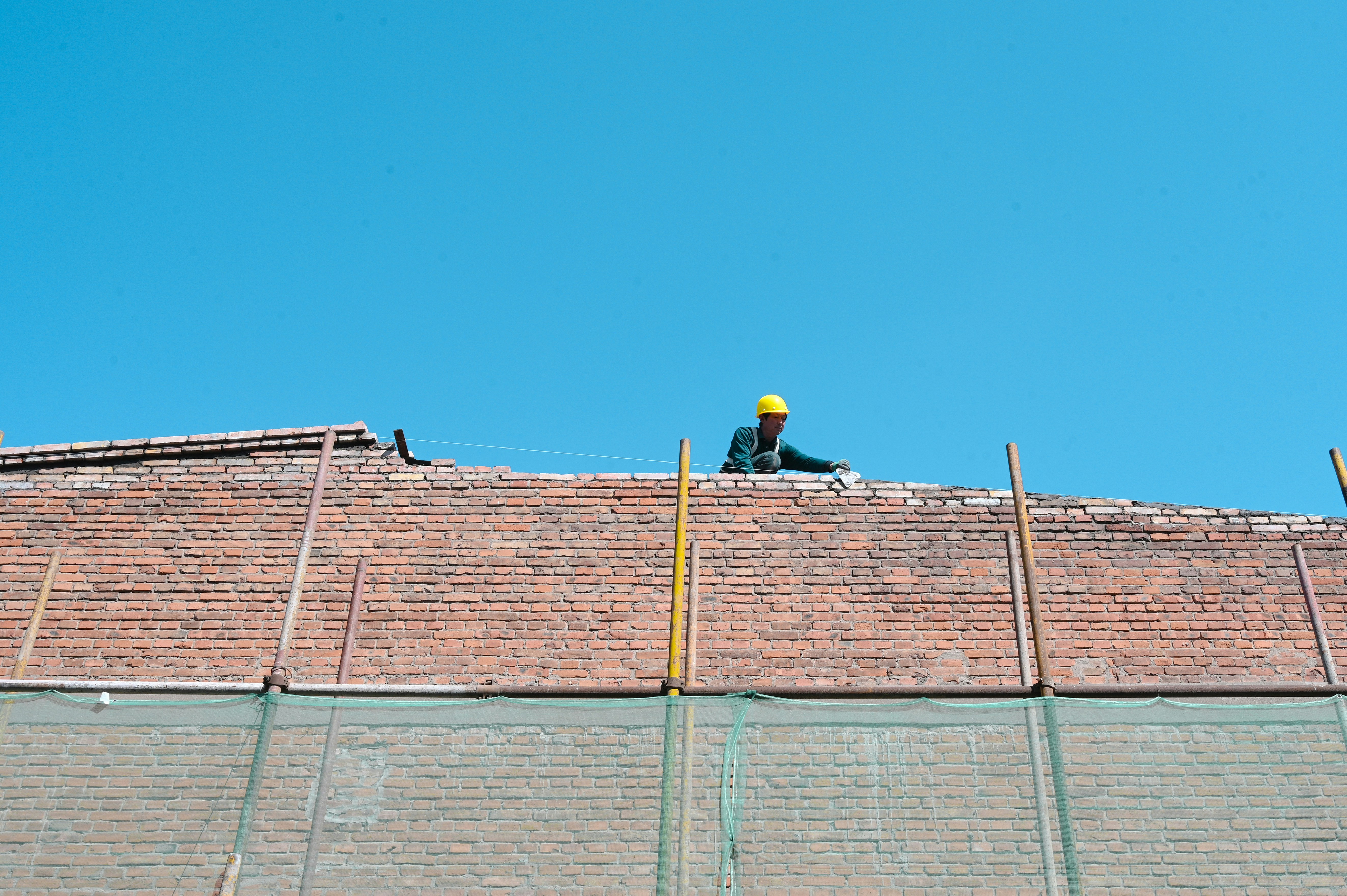 Une personne au sommet d’un toit photo – Photo Brique Gratuite sur Unsplash