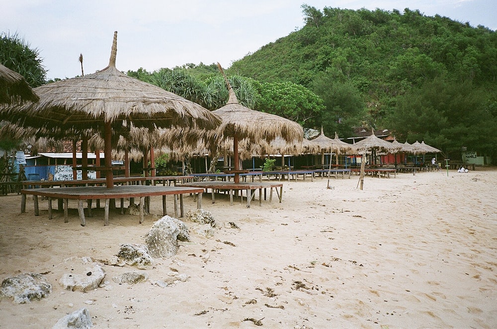 a beach with straw umbrellas