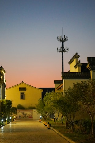 Technicians installing broadband cables on a quiet residential street at dusk.