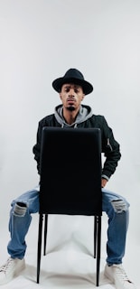 A sleek black jacket styled with jeans, photographed in a minimalist studio.