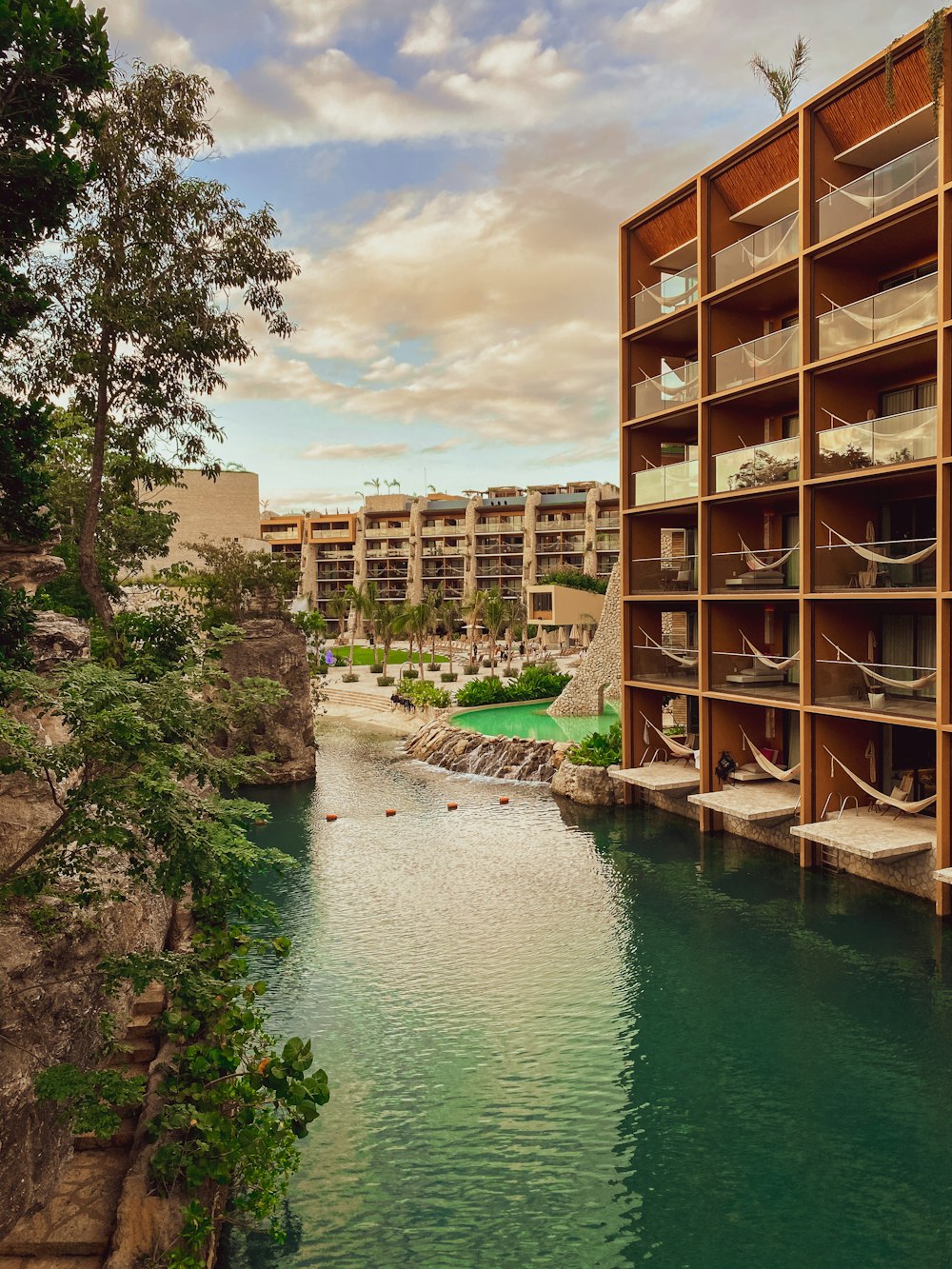 un bâtiment avec une piscine et des arbres