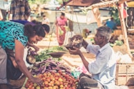 A friendly shopkeeper weighing fresh produce for a smiling customer.