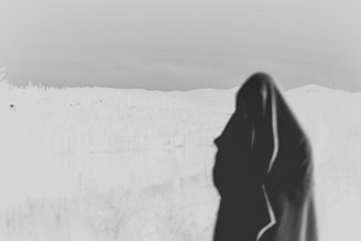 A wide shot of a mysterious figure silhouetted against a vast, otherworldly landscape.