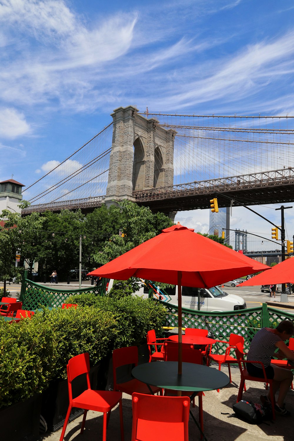 a group of people sitting at tables in front of a large bridge