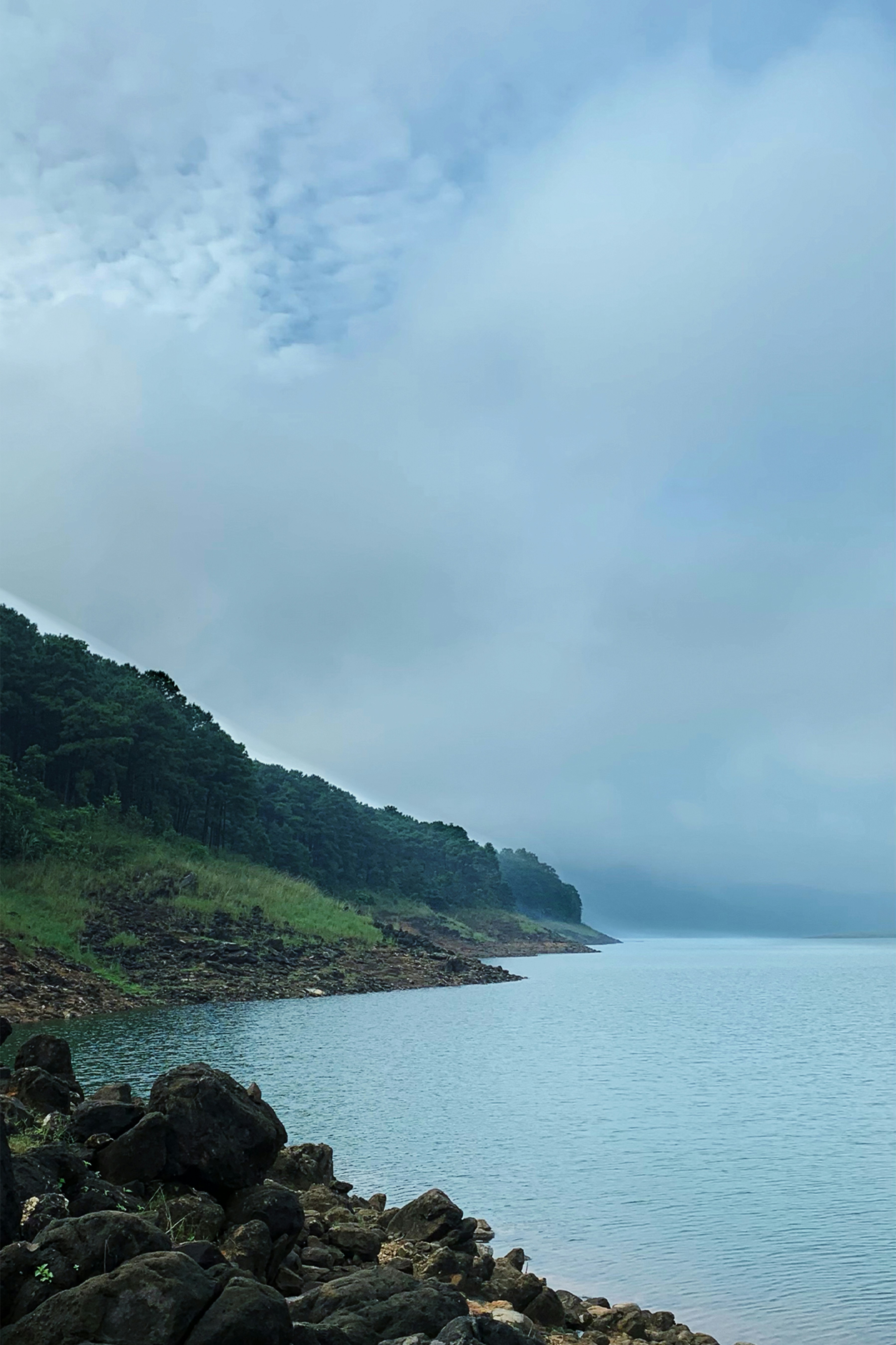 a body of water with rocks and trees around it