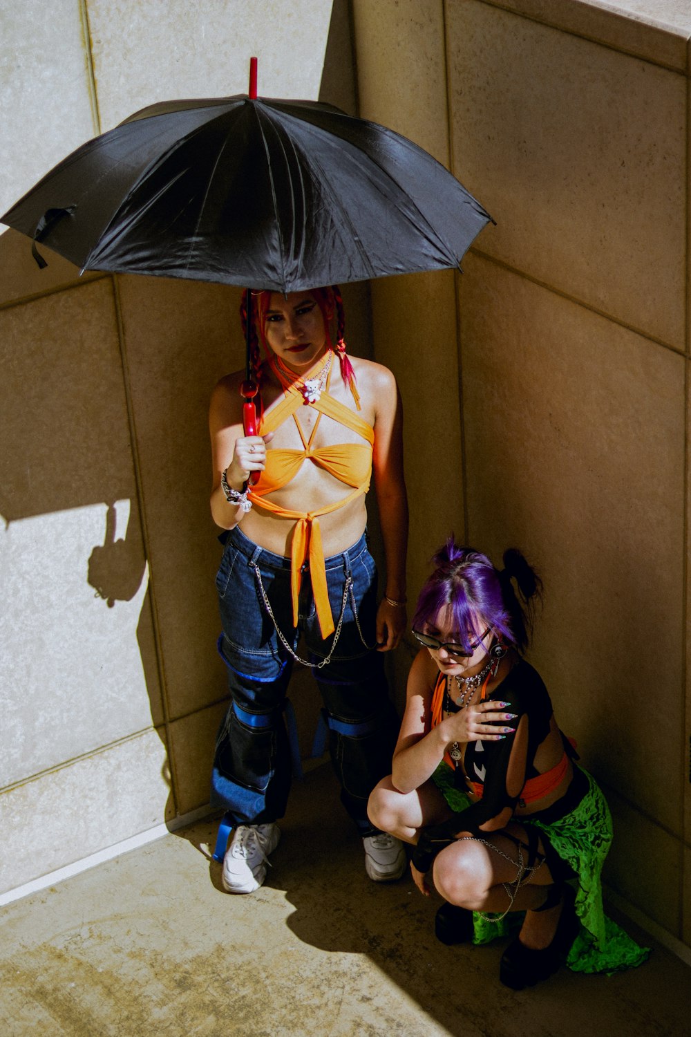 a couple of people wearing clothing and holding an umbrella