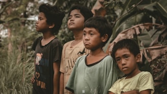 a group of boys standing in a forest