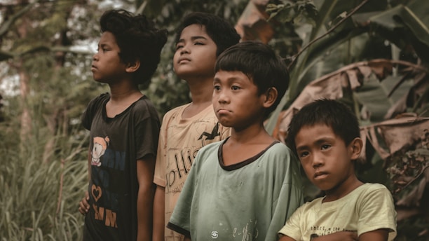 a group of boys standing in a forest