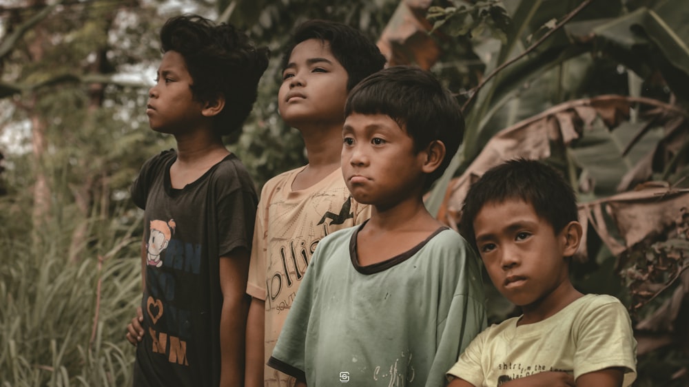 a group of boys standing in a forest