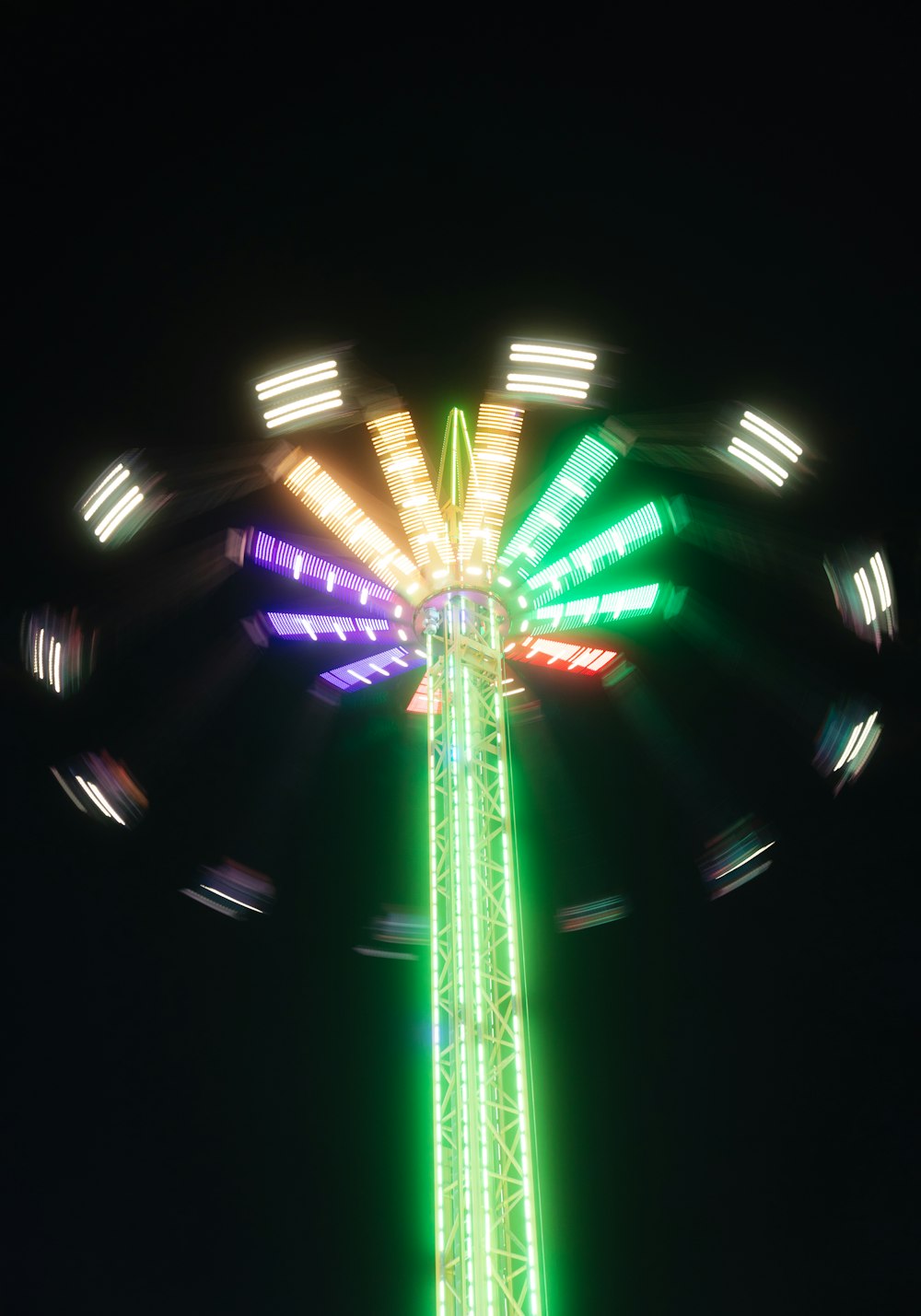 a tall green and yellow ferris wheel