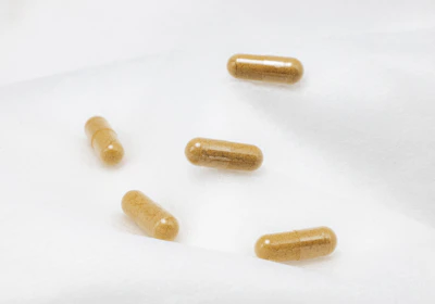 Close-up of multivitamin capsules spilling gently on a clean white surface.