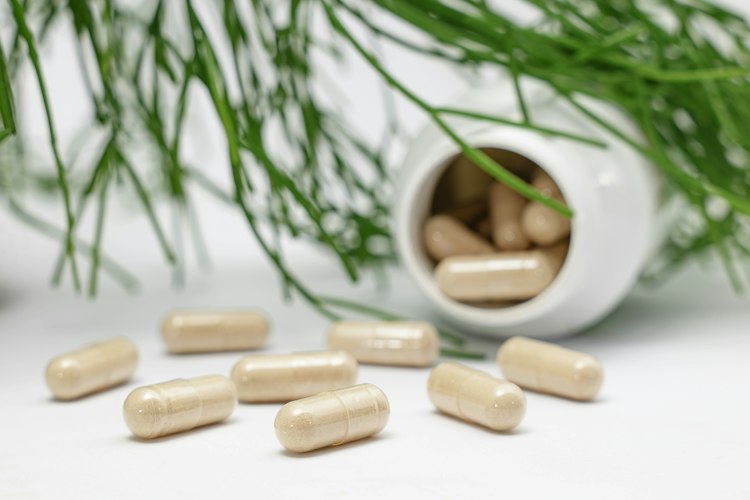 Close-up of a hand reading the supplement facts label on a vitamin bottle