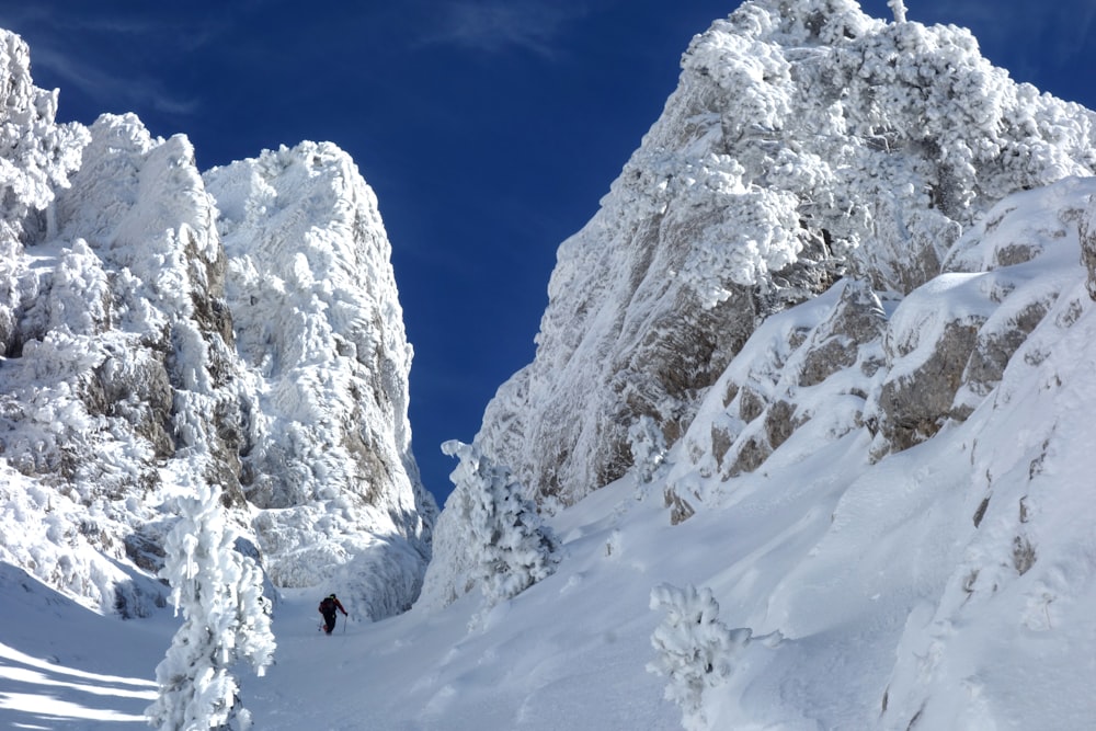 una persona che cammina su una montagna innevata