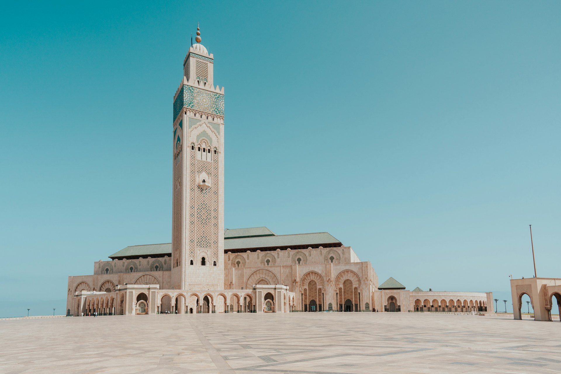 a large building with a tall tower with Hassan II Mosque in the background