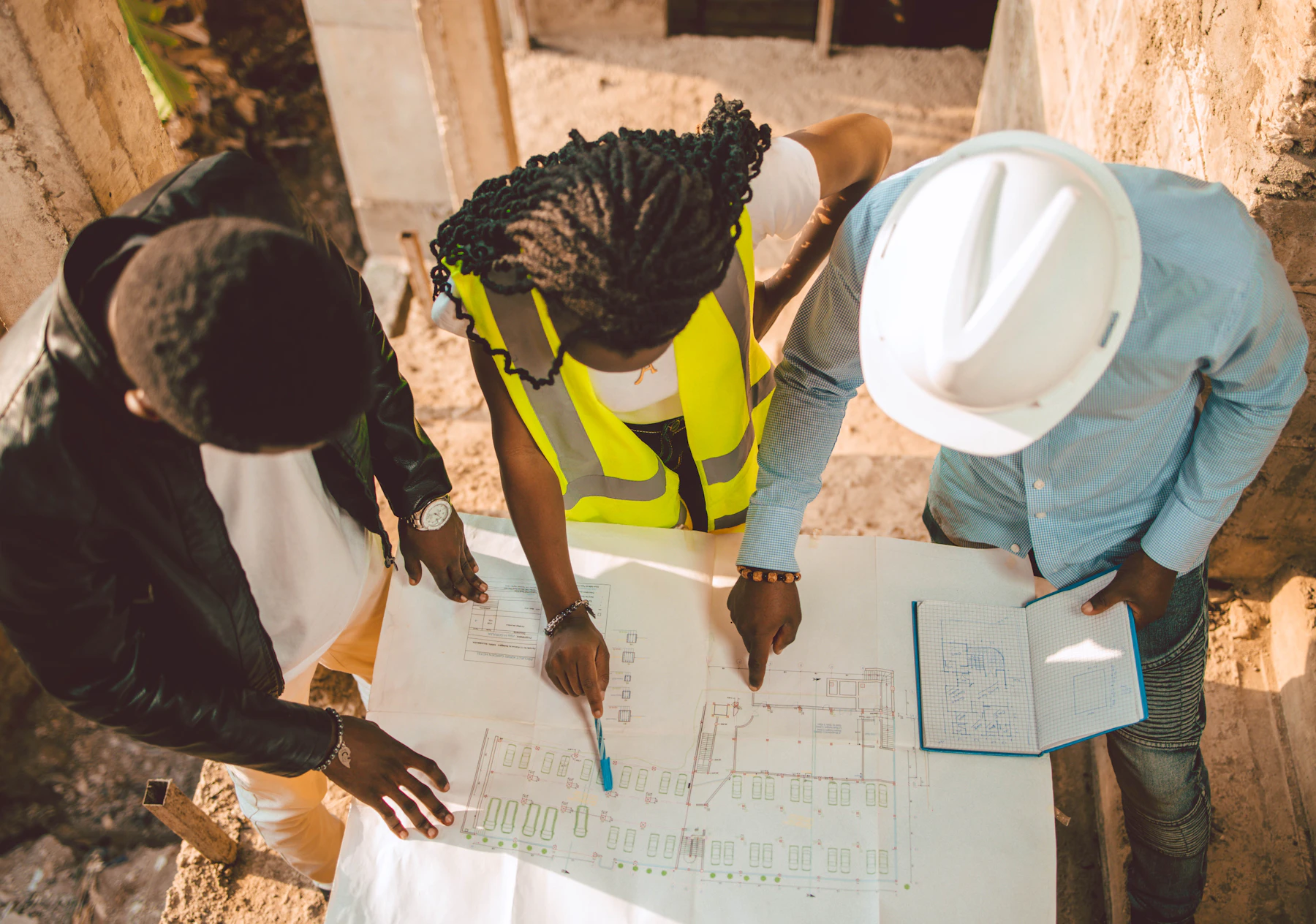 Construction professionals reviewing architectural plans inside an unfinished building