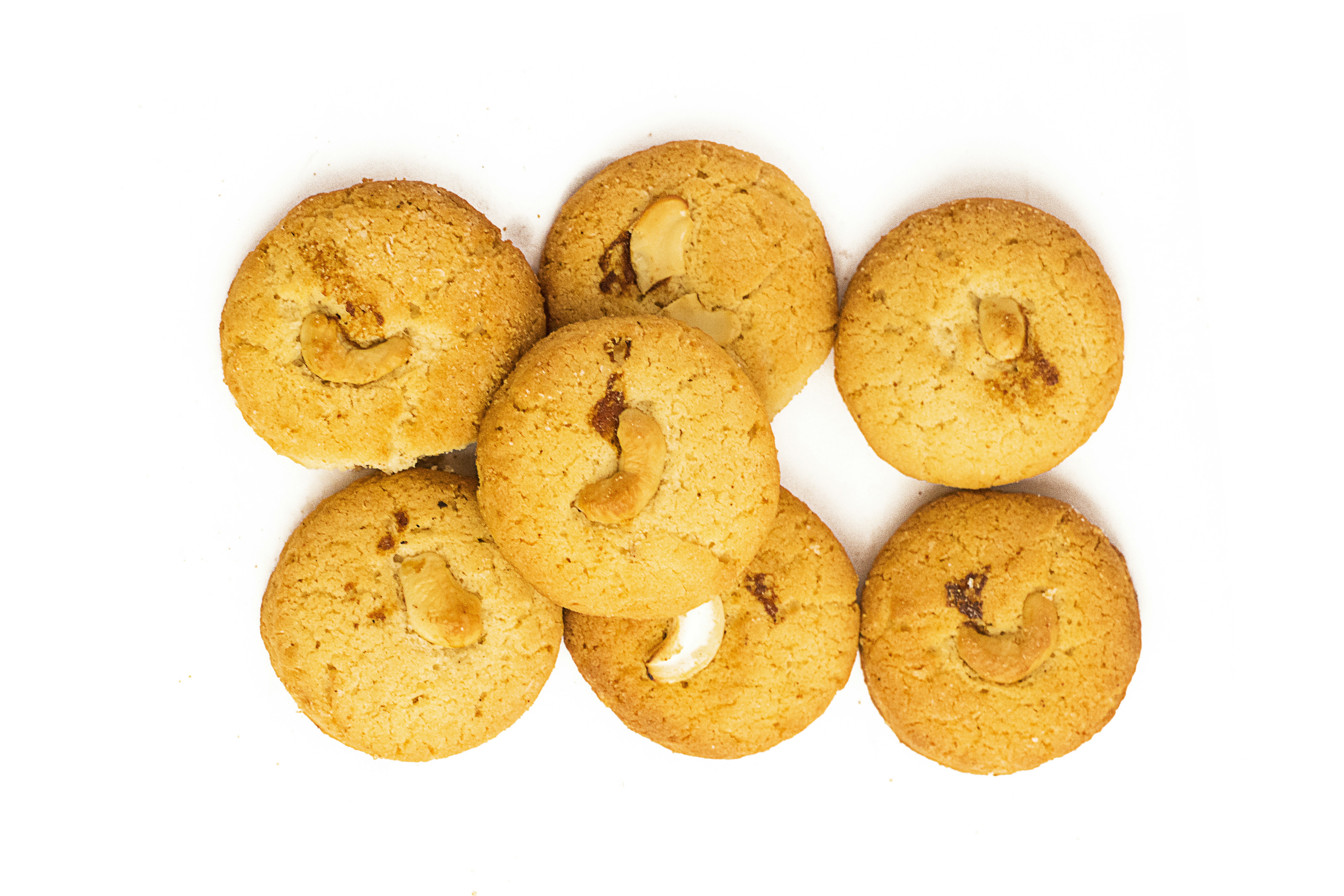 Round butter biscuits with cashews on cream background