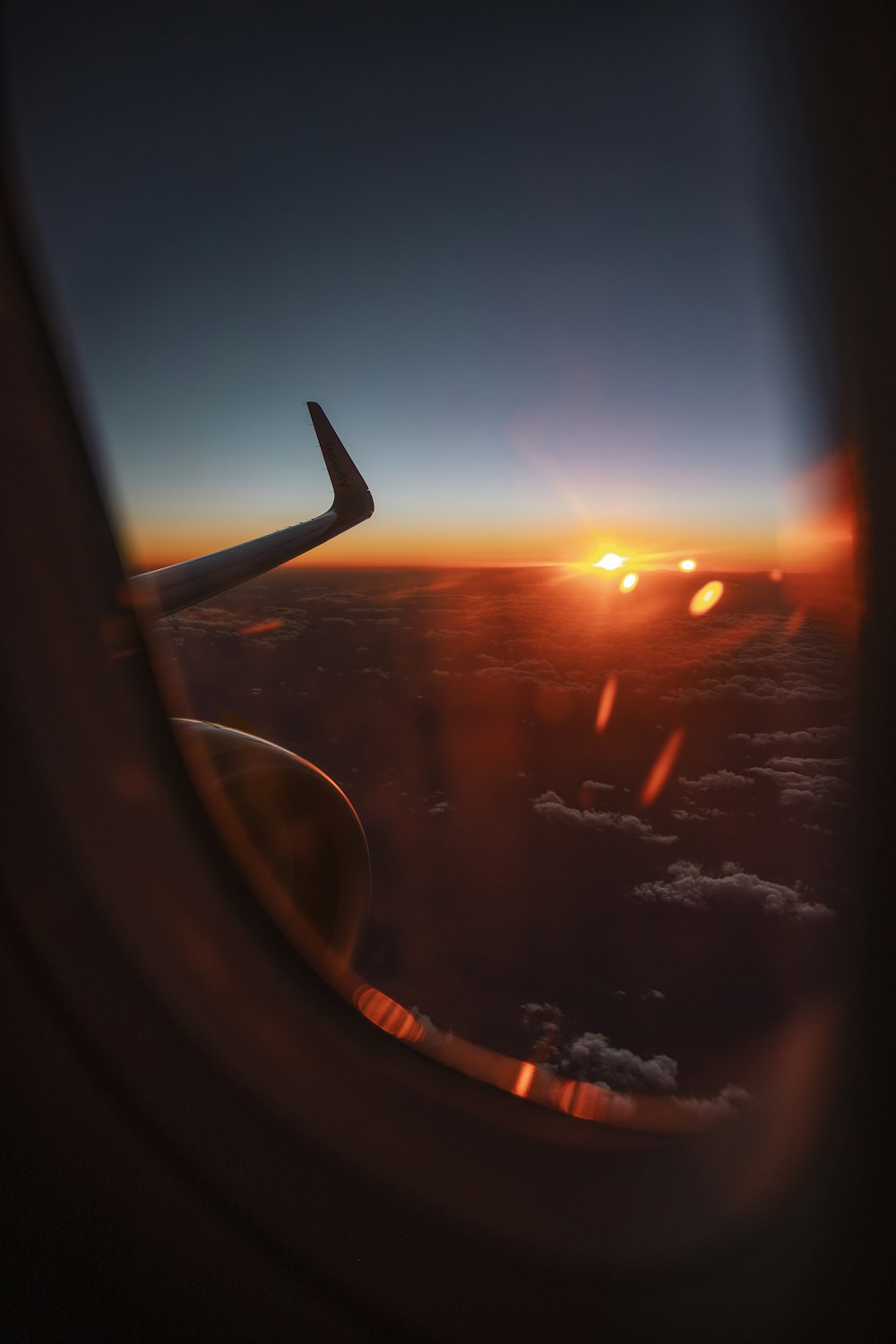 a view of the wing of an airplane at sunset