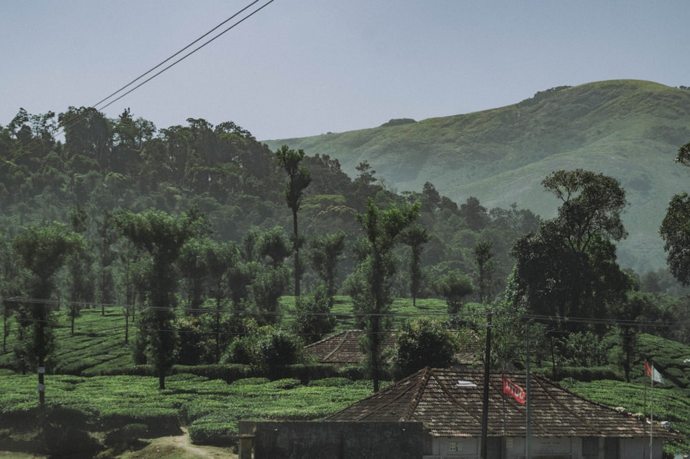 a house with trees and hills in the background