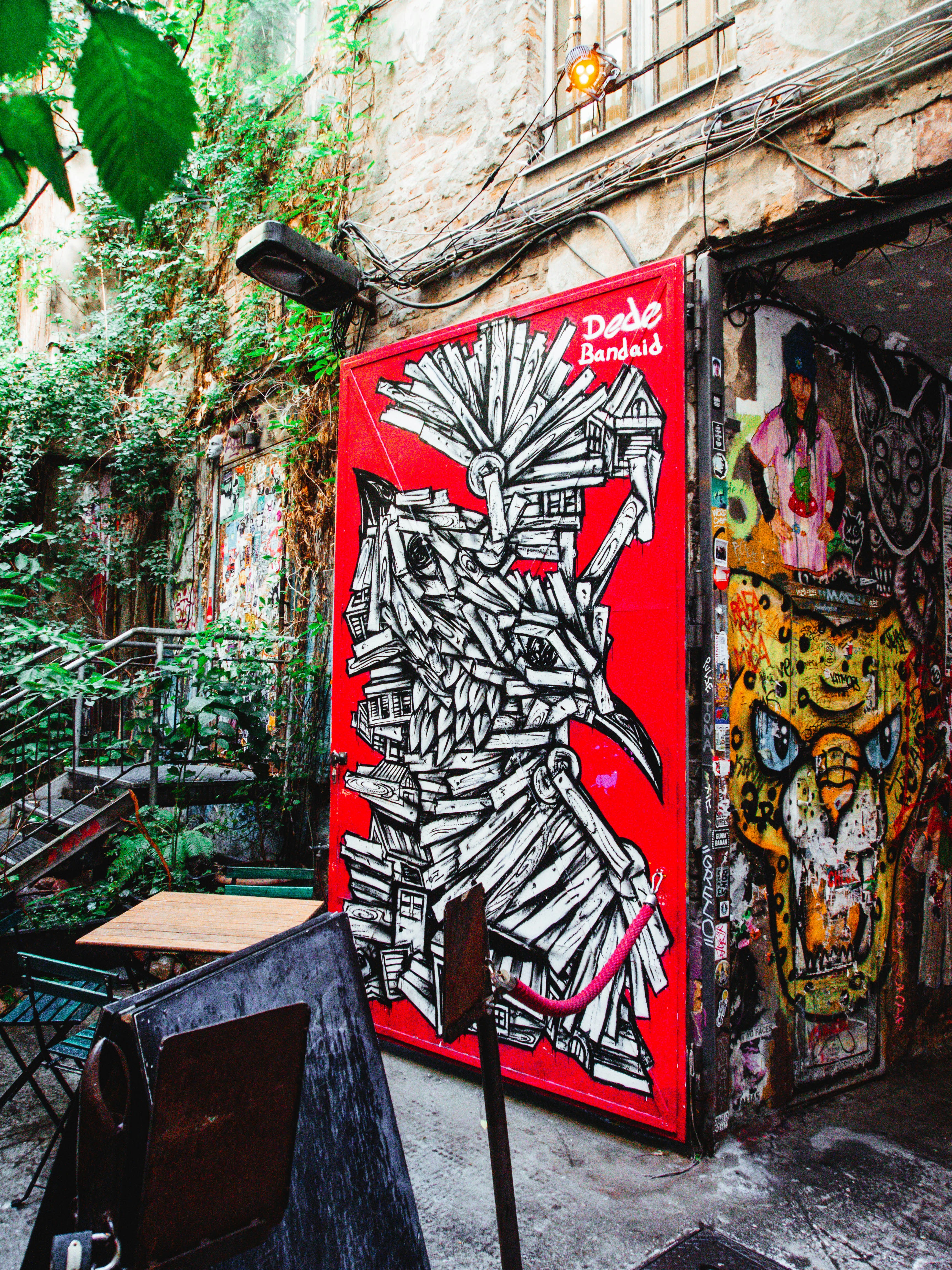 a red and black wall with graffiti