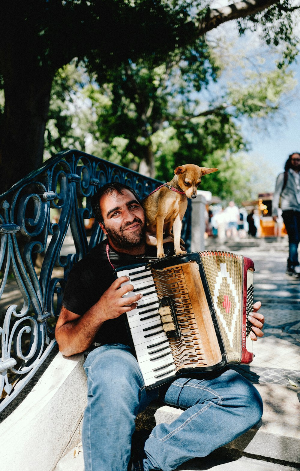 a man sitting on a bench with a dog on his back