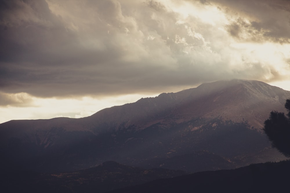 a mountain with clouds above it